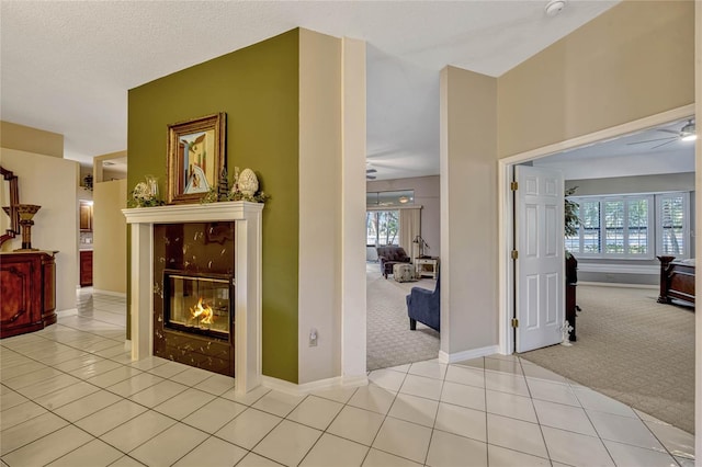 hall featuring light tile patterned floors, light carpet, and plenty of natural light