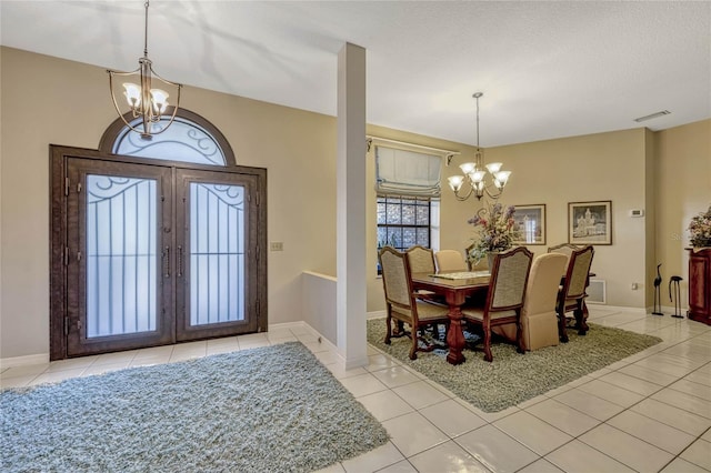 entryway with visible vents, baseboards, a notable chandelier, and light tile patterned flooring