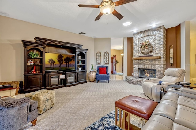 living room with carpet flooring, visible vents, a brick fireplace, and ceiling fan