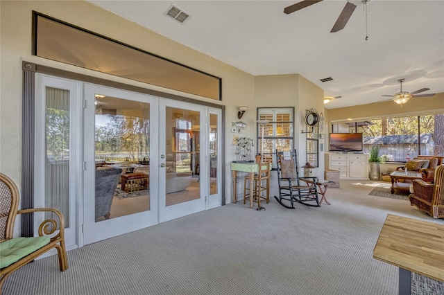 sunroom with visible vents, french doors, and a ceiling fan