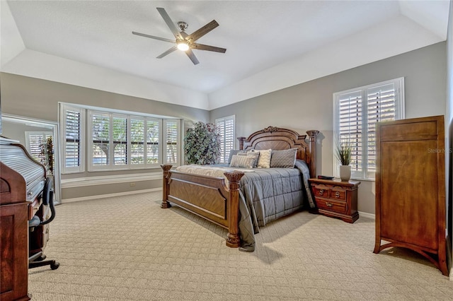 bedroom featuring ceiling fan, a raised ceiling, baseboards, and carpet floors