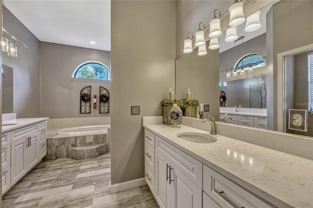 full bathroom featuring a bath, vanity, and baseboards