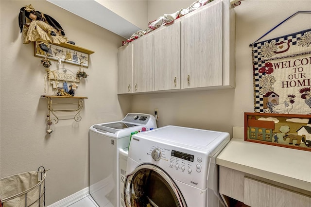 clothes washing area with cabinet space, baseboards, and washing machine and clothes dryer