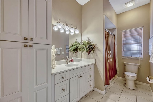 bathroom with tile patterned flooring, toilet, vanity, and baseboards