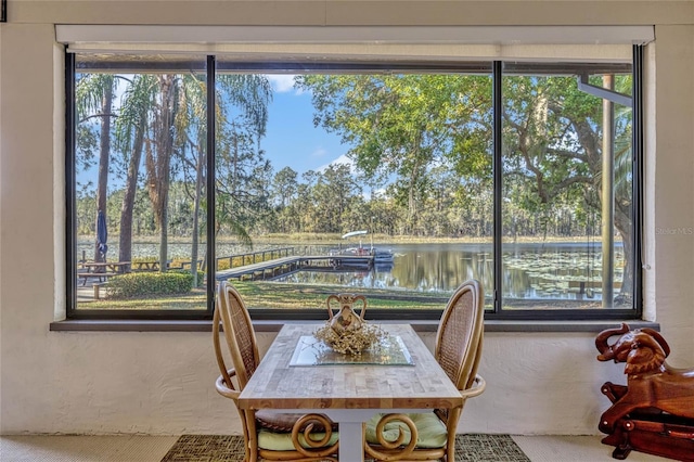 dining room featuring a textured wall and a water view