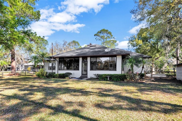 view of front of property with a front yard and stucco siding