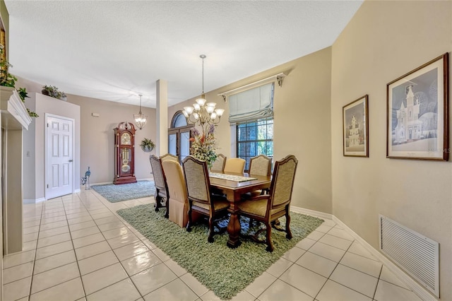 dining space featuring a notable chandelier, baseboards, visible vents, and light tile patterned floors