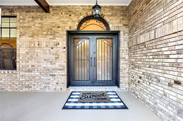 view of exterior entry with french doors and brick siding