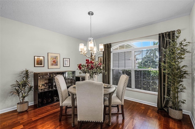 dining room with a notable chandelier, baseboards, wood-type flooring, and a textured ceiling