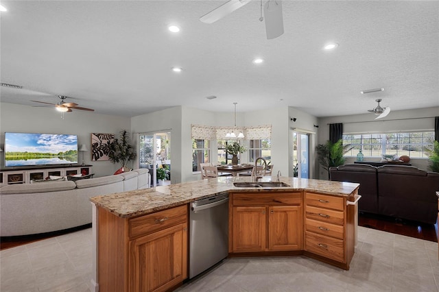 kitchen with open floor plan, stainless steel dishwasher, an island with sink, and a sink