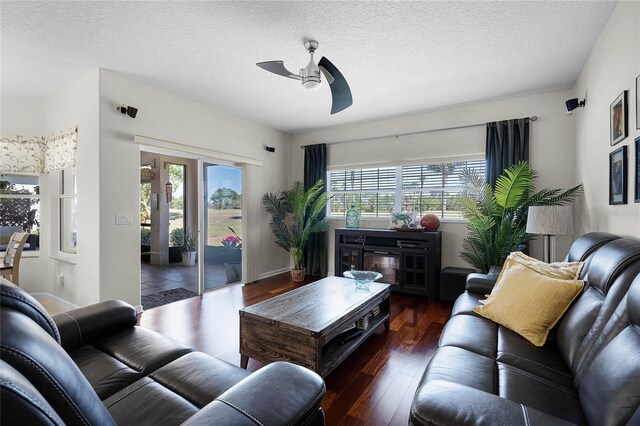 living area featuring a textured ceiling, a healthy amount of sunlight, wood-type flooring, and ceiling fan