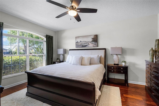 bedroom featuring ceiling fan, baseboards, a textured ceiling, and wood finished floors