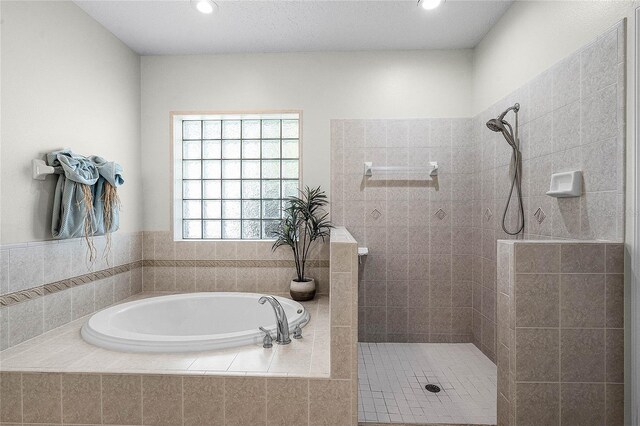 bathroom featuring a bath, recessed lighting, and a walk in shower