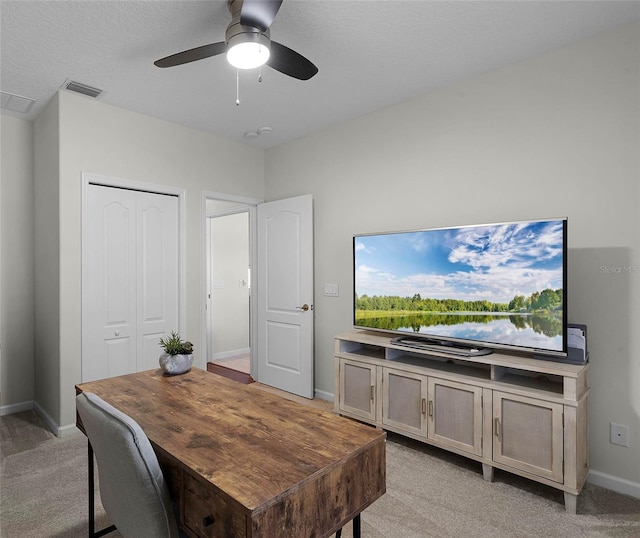 office featuring visible vents, baseboards, light colored carpet, and a ceiling fan