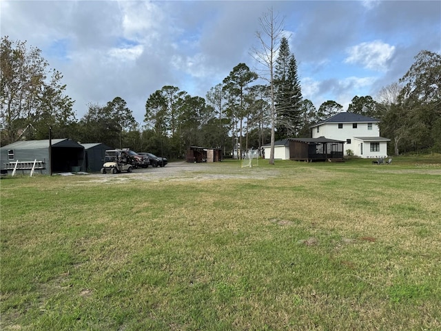 view of yard with an outdoor structure, a garage, and a pole building