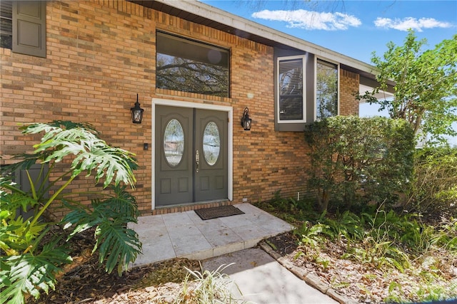 entrance to property featuring brick siding