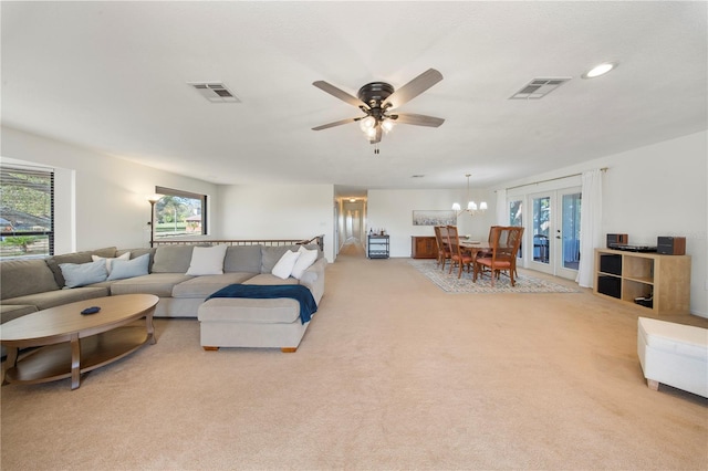 living room with light colored carpet, ceiling fan with notable chandelier, french doors, and visible vents