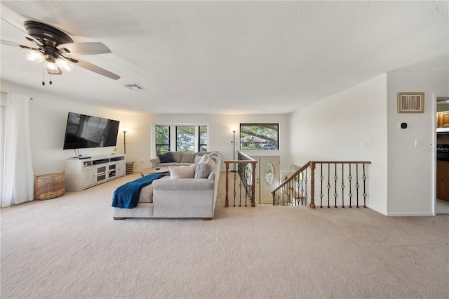 living room featuring visible vents, a textured ceiling, and carpet floors