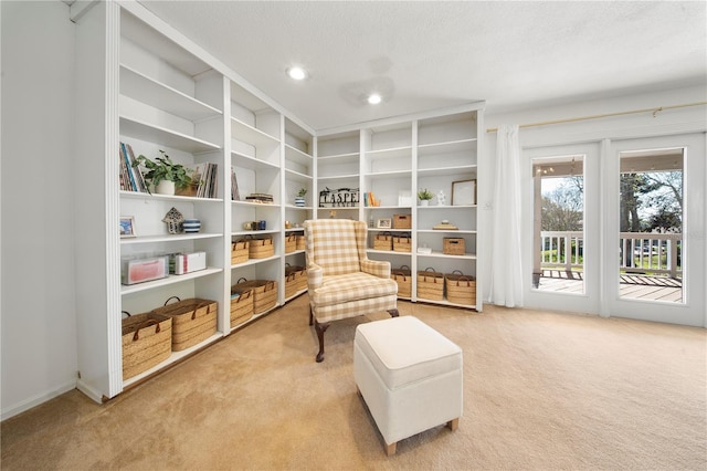 living area featuring light carpet, recessed lighting, and a textured ceiling