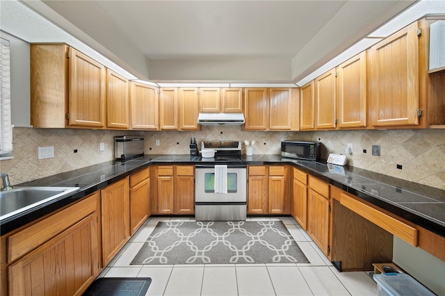 kitchen with under cabinet range hood, electric range, backsplash, and a sink