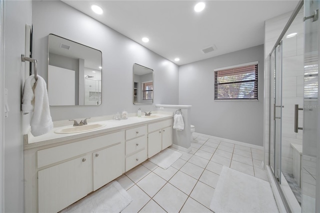 bathroom with tile patterned flooring, a stall shower, and a sink