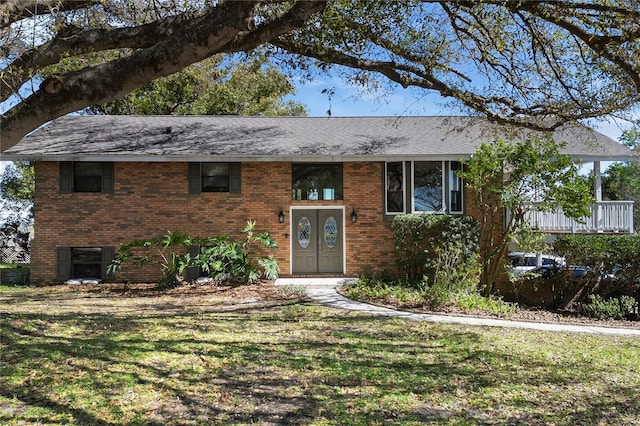 view of front of property featuring a front yard and brick siding