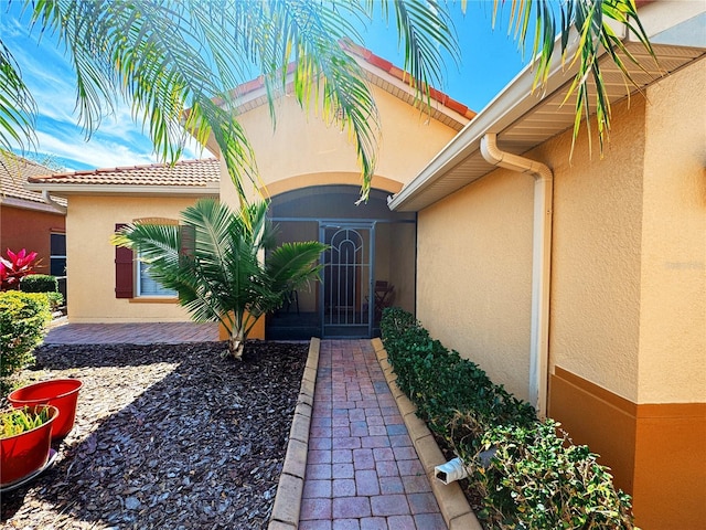 entrance to property featuring stucco siding and a gate