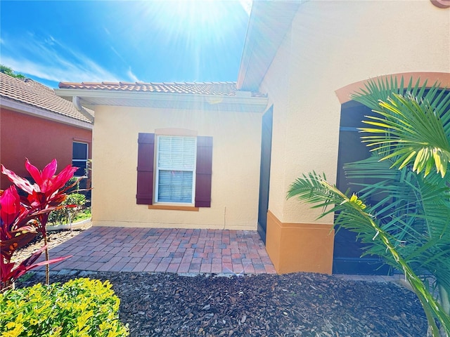 property entrance featuring a patio area and stucco siding