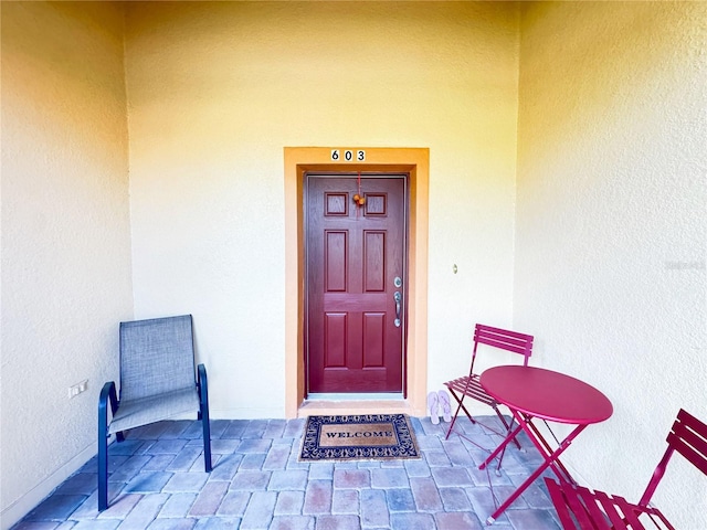 property entrance with stucco siding