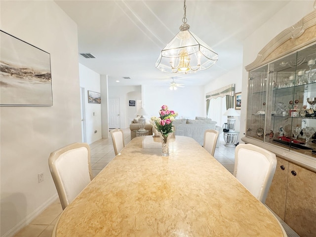 dining room with light tile patterned floors, visible vents, and ceiling fan with notable chandelier