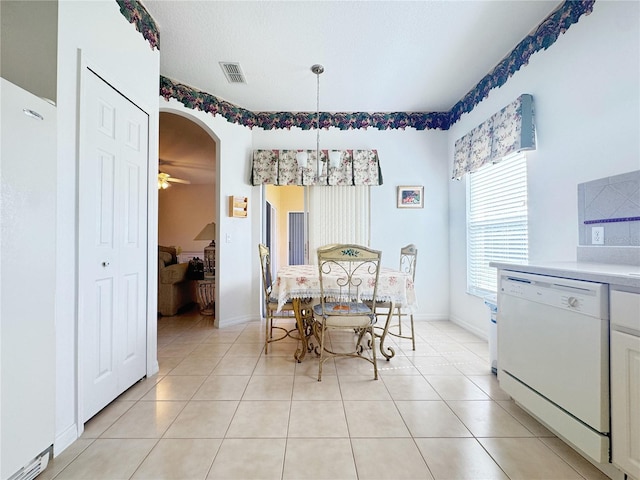 dining room with visible vents, baseboards, light tile patterned floors, arched walkways, and a ceiling fan