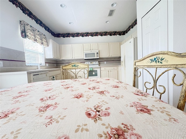 kitchen featuring visible vents, tasteful backsplash, recessed lighting, white appliances, and light countertops