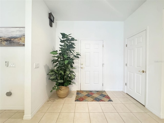 entrance foyer with light tile patterned flooring and baseboards