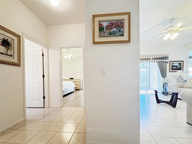 hall with light tile patterned floors and baseboards