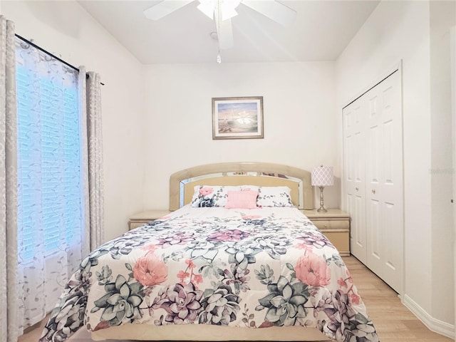 bedroom with baseboards, light wood-type flooring, a closet, and ceiling fan