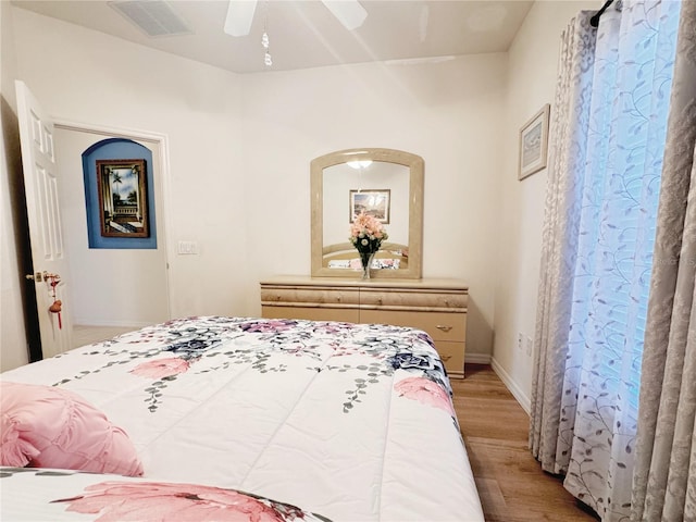 bedroom featuring visible vents, baseboards, light wood-style floors, and ceiling fan