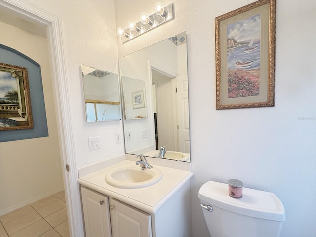 half bathroom with tile patterned floors, toilet, and vanity