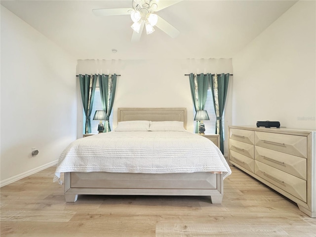 bedroom featuring baseboards, light wood-style flooring, and a ceiling fan