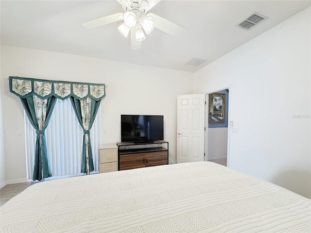 bedroom featuring visible vents, baseboards, wood finished floors, and a ceiling fan