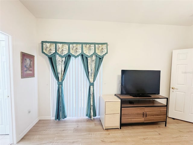 interior space featuring baseboards and light wood finished floors