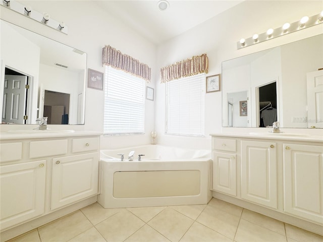 bathroom with a sink, a garden tub, and tile patterned flooring