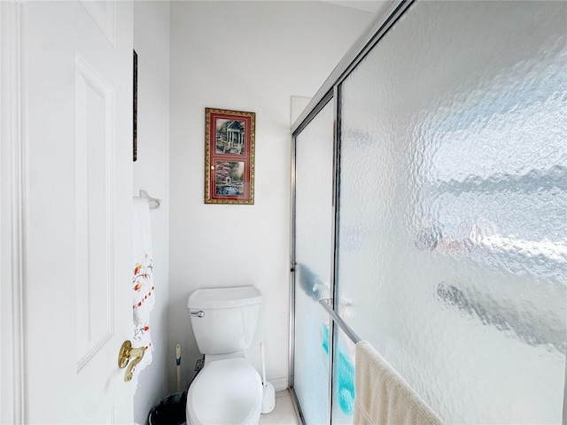 bathroom with a shower stall and toilet