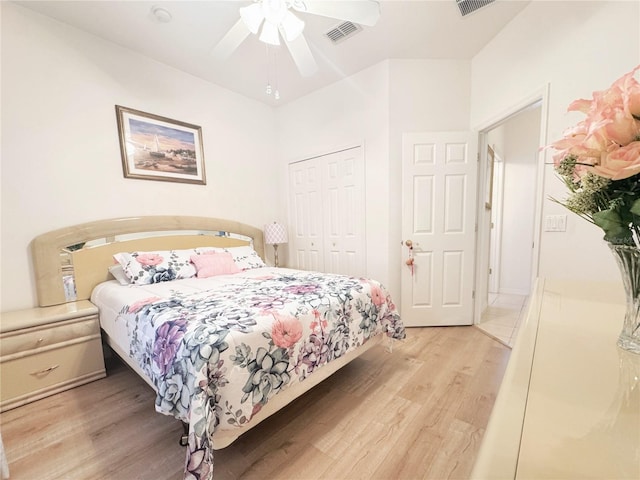 bedroom featuring light wood-type flooring, visible vents, a closet, and a ceiling fan