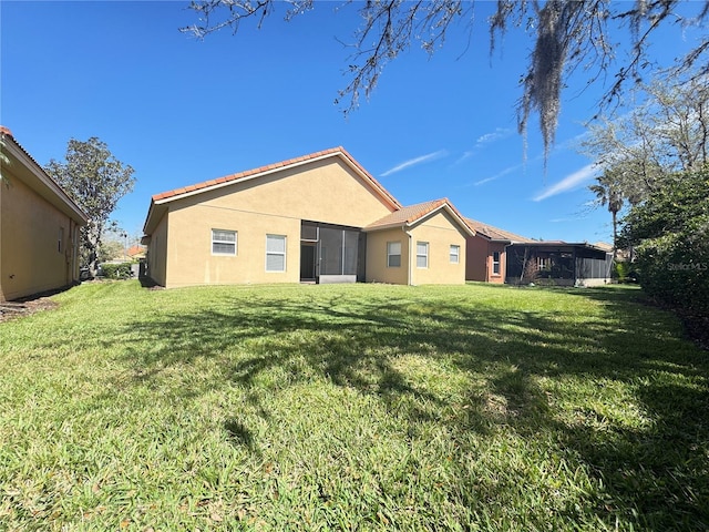 back of house featuring a lawn and stucco siding