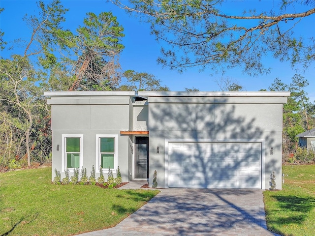 view of front of house with a garage, decorative driveway, a front yard, and stucco siding