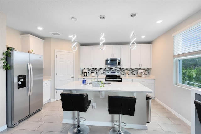 kitchen with visible vents, white cabinetry, appliances with stainless steel finishes, light countertops, and decorative backsplash