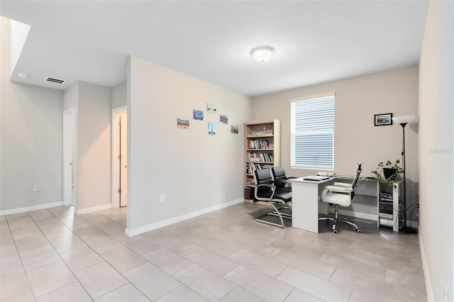 home office with light tile patterned floors, baseboards, visible vents, and a textured ceiling