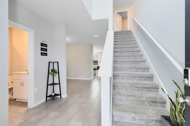 stairway featuring visible vents and baseboards