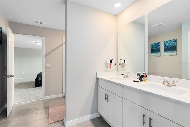 bathroom featuring double vanity, visible vents, and a sink