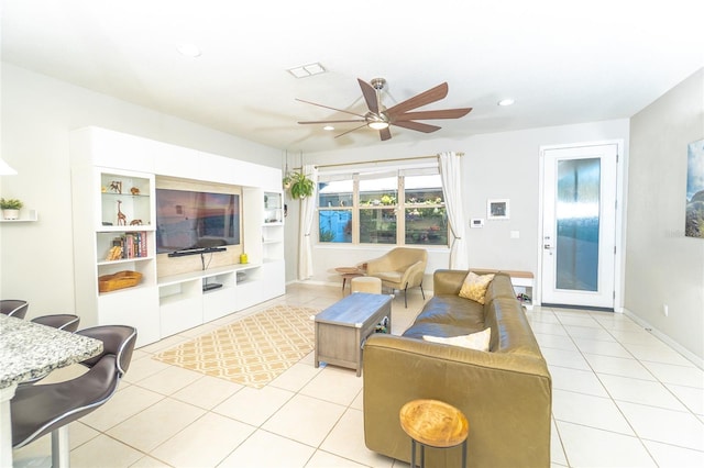 living area featuring light tile patterned floors, a ceiling fan, recessed lighting, and baseboards
